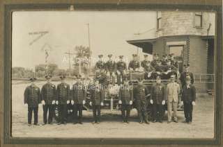 Firefighters with badges uniforms by fire engine truck antique photo