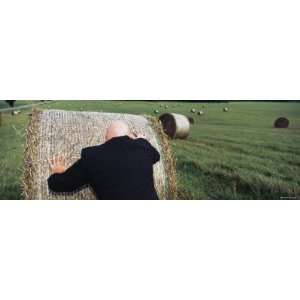  Man Pushing a Hay Bale in a Field, Germany Photographic 