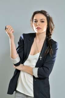 Pretty model wearing a cross pedant on a long chain with a blazer and 